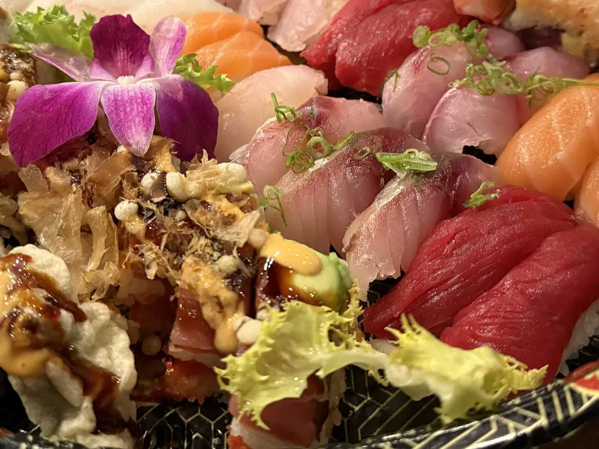 Sushi party tray of nigiri w/an orchid garnish